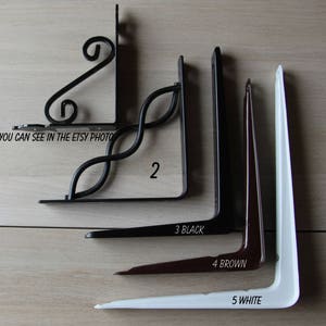K&ouml;nnte beinhalten: F&uuml;nf verschiedene Metall-Regalb&ouml;cke. Der erste Regalbock ist ein dekoratives Rollendesign. Der zweite Regalbock ist ein einfaches, geschwungenes Design. Der dritte Regalbock ist schwarz, der vierte ist braun und der f&uuml;nfte ist wei&szlig;.