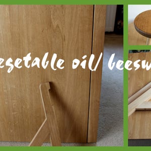 May include: Close-up of a wooden table top with a natural wood finish. The table top is treated with vegetable oil and beeswax. The text "vegetable oil/beeswax" is written in white on the table top.