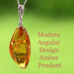 May include: A modern amber pendant with an angular design, suspended from a silver chain. The amber has a warm, golden-yellow hue with internal inclusions. The text on the image reads "Modern Angular Design Amber Pendant."