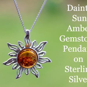 Op de afbeelding: Een zilveren zon hanger met een amber edelsteen. De hanger is aan een zilveren ketting.