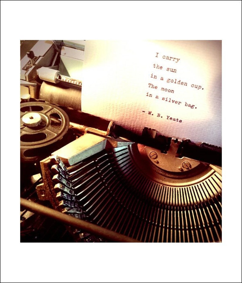 May include: A vintage typewriter with a sheet of paper in it. The paper has a poem typed on it that reads: "I carry the sun in a golden cup. The moon in a silver bag. - W. B. Yeats"