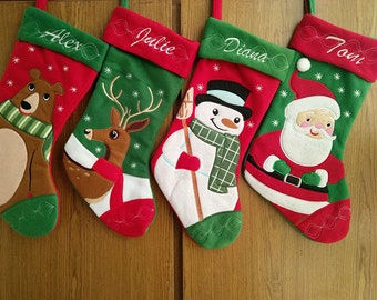 May include: Four Christmas stockings with embroidered names: Alex, Julie, Diana, and Tom. Each stocking features a different festive design: a bear, a reindeer, a snowman, and Santa Claus. The stockings are red and green with white accents.