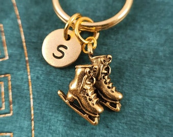 May include: Gold ice skate charm keychain with a gold initial charm with the letter "S" on a gold key ring.