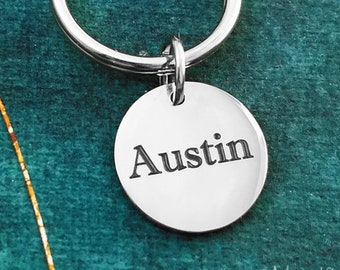 May include: Silver keychain with a round tag that says "Austin" on it.