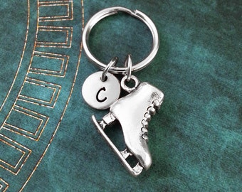 May include: Silver ice skate charm with a silver initial 'C' charm attached to a silver key ring.