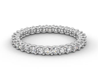 May include: A silver eternity band with a row of round, clear diamonds set in a pave setting.