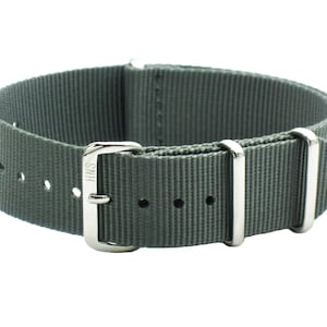 May include: A gray nylon watch strap with silver buckle and keepers. The buckle has the word "SAIH" engraved on it.