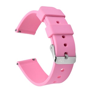May include: A pink silicone watch band with a silver buckle. The buckle has the text "HNS" on it.