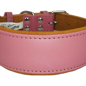 May include: A pink leather dog collar with a brown suede lining and silver buckle. The collar has a stitched edge and four silver rivets.