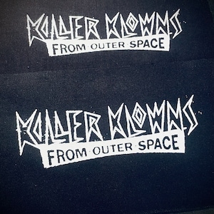 May include: Two black fabric patches with white text. The text reads "Killer Klowns from Outer Space".