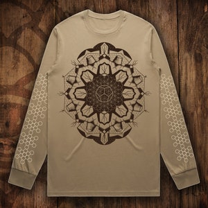 May include: A tan long-sleeve shirt with a brown geometric mandala design on the front and a white honeycomb pattern on the sleeves.