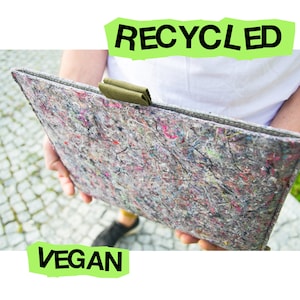 Könnte beinhalten: Eine rechteckige Laptoptasche aus recycelten Materialien. Die Tasche hat ein gesprenkeltes Aussehen mit einem grünen Stoffgriff. Die Wörter "RECYCLED" und "VEGAN" stehen in grüner Schrift. Die Tasche wird von einer Person gehalten.