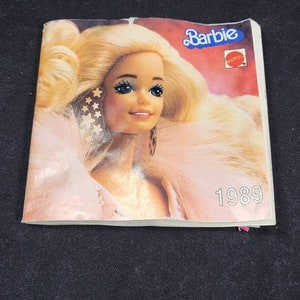 May include: A vintage Barbie catalogue from 1989. The cover features a blonde Barbie doll with a pink fur collar and the text "Barbie" and "Mattel".