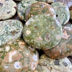 Puede incluir: Una colecci&oacute;n de piedras de jaspe oce&aacute;nico pulidas de color verde, marr&oacute;n y blanco. Las piedras son lisas y tienen una variedad de patrones y texturas.