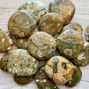 Puede incluir: Una colecci&oacute;n de piedras de jaspe oce&aacute;nico pulidas de color verde, marr&oacute;n y blanco. Las piedras son lisas y tienen una variedad de patrones y texturas.