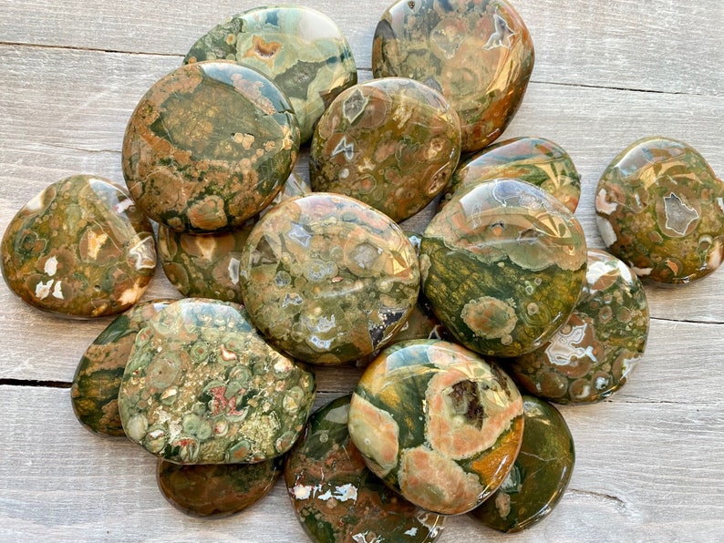 Puede incluir: Una colecci&oacute;n de piedras de jaspe oce&aacute;nico pulidas de color verde, marr&oacute;n y blanco. Las piedras son lisas y tienen una variedad de patrones y texturas.