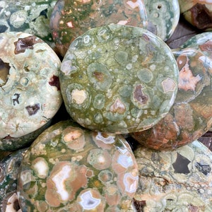 Puede incluir: Una colecci&oacute;n de piedras de jaspe oce&aacute;nico pulidas de color verde, marr&oacute;n y blanco. Las piedras son lisas y tienen una variedad de patrones y texturas.