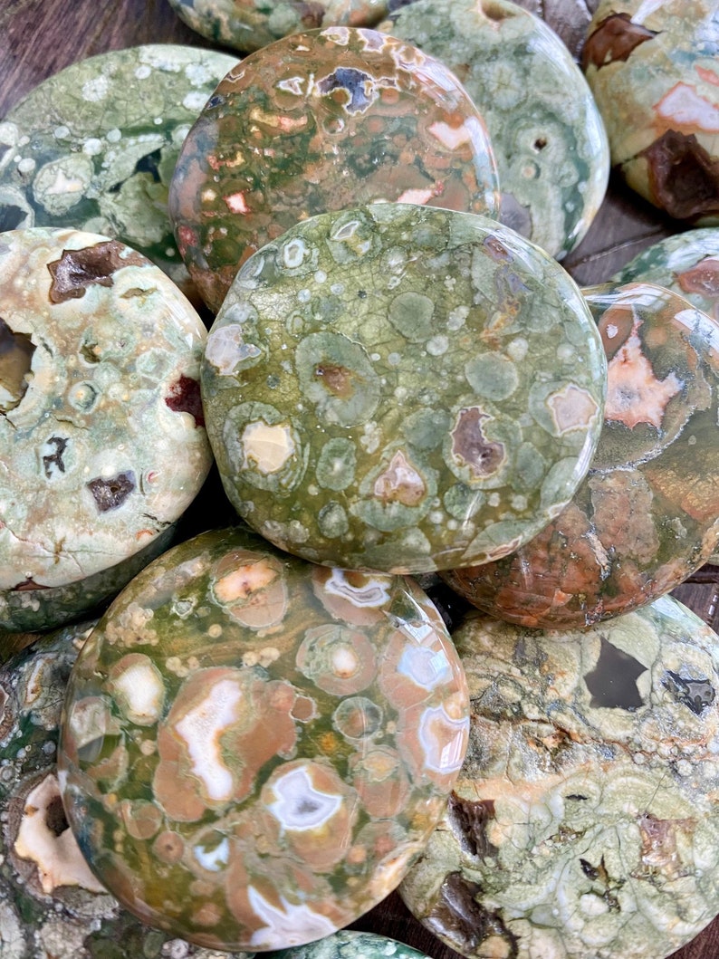 Puede incluir: Una colecci&oacute;n de piedras de jaspe oce&aacute;nico pulidas de color verde, marr&oacute;n y blanco. Las piedras son lisas y tienen una variedad de patrones y texturas.