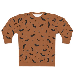 May include: A brown sweatshirt with a black bat pattern. The bats are scattered randomly across the sweatshirt.