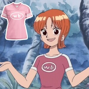 May include: A pink t-shirt with white trim and the letters "wb" in a white oval. The shirt is worn by a cartoon character with orange hair.