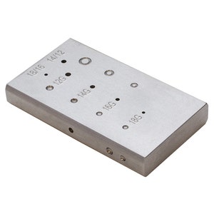 May include: A silver metal gauge with holes of different sizes, labeled with gauge sizes from 18/16 to 18G.