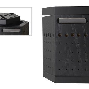 May include: Black hexagonal wooden box with a lid that has a grid of holes. The box has a silver metal handle.