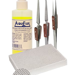May include: A set of jewelry making tools including a bottle of Aquiflux self-pickling liquid hard soldering flux, three pairs of tweezers, and a white ceramic soldering block.