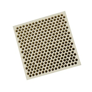 May include: A white ceramic honeycomb-shaped object with a square base and many small holes.