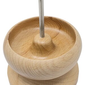May include: A wooden bead organizer with a metal rod and a brass knob. The organizer has a round base and a bowl-shaped top.