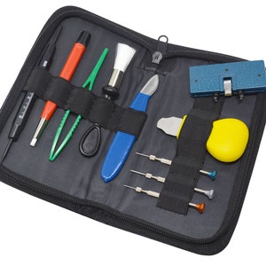 May include: A black zippered case with a variety of watch repair tools, including a watch press, tweezers, screwdrivers, and a small brush.