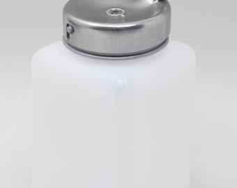 Op de afbeelding: Een witte plastic fles met een zilveren metalen dop en een klepdeksel. De fles is vierkant en heeft een klein gaatje in de dop.