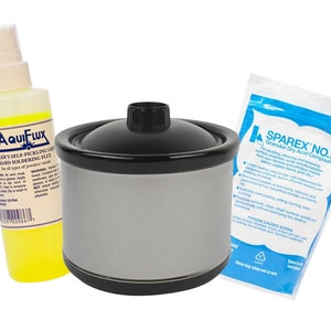 Op de afbeelding: Een set juweliersbenodigdheden, waaronder een flesje gele vloeistof met het label "Aquiflux Jeweler's Self-Pickling Liquid Hard Soldering Flux", een witte slowcooker met een zwarte deksel en een blauwe en witte zak met het label "Sparex No. 2 Granular Dry Acid Compound".
