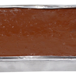 May include: A rectangular block of brown chocolate fudge in a silver foil-lined pan.