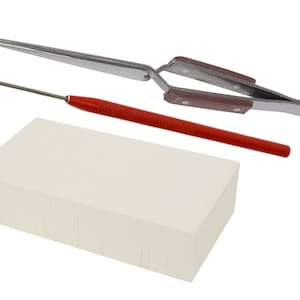 May include: A set of tools for crafting and jewelry making, including a pair of tweezers with brown handles, a red and silver tool with a pointed tip, and a white rectangular block.