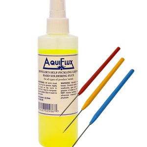 May include: A yellow bottle of Aquiflux Jeweler's Self-Pickling Liquid Hard Soldering Flux for all types of jewelers' metals. The bottle is labeled with instructions and warnings. Three metal tools are included: a red, a yellow, and a blue tool.