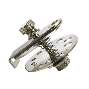 May include: A silver metal sewing machine foot with a spring and a knob. The foot has a circular base with multiple holes.