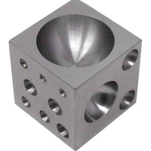 Peut inclure: Un cube en métal argenté avec plusieurs dépressions rondes sur chaque face. Le cube a une grande dépression ronde sur le dessus.