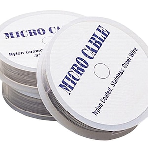 May include: Three spools of Micro Cable nylon-coated stainless steel wire. The spools are white with blue text that reads "MICRO CABLE" and "Nylon Coated, Stainless Steel Wire". The wire is a silver color and is tightly wound on the spools.