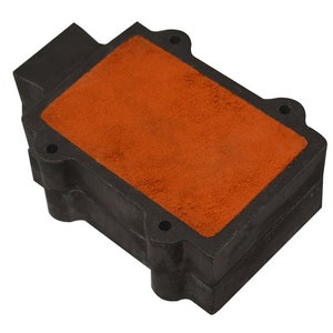 May include: A black rectangular air filter with an orange foam insert. The filter has multiple holes and a textured surface.