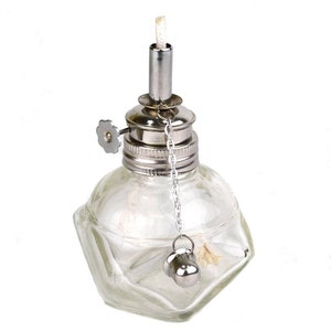 May include: A clear glass spirit lamp with a silver metal top and a wick. The lamp has a chain with a small silver ball attached.