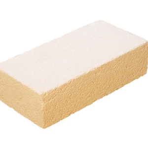 Puede incluir: Un ladrillo beige claro con una superficie rugosa y texturizada. El ladrillo tiene una capa de polvo blanco en la parte superior.