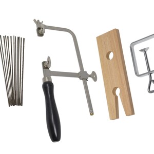 May include: A silver-toned coping saw with a black handle, a wooden clamp with two holes, a silver-toned clamp with a screw, and a bundle of 12 silver-toned saw blades.
