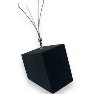 May include: A black wooden block with a silver metal wire attached to the top. The wire has five prongs extending upwards.