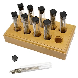 May include: A wooden storage box with 10 clear plastic tubes containing drill bits. The tubes are arranged in a grid pattern and have black caps. The box is light brown and has a smooth finish.