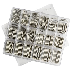 Può includere: Una scatola di plastica trasparente piena di perni per cinturini di orologi argentati assortiti. La scatola è etichettata con diverse dimensioni in millimetri: 7 mm, 13 mm, 18 mm, 24 mm e 12 mm.