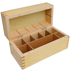 以下が含まれることがあります： 蓋付きの仕切り付きの木箱。箱は明るい色の木でできており、自然な仕上げになっています。箱の内側はいくつかの区画に分けられています。