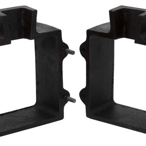 Könnte beinhalten: Zwei schwarze quadratische Metallboxen mit einer rechteckigen Öffnung an der Vorderseite. Die Boxen haben einen erhöhten Rand an der Oberseite und vier kleine Löcher an den Seiten.