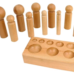 Puede incluir: Un conjunto de punzones circulares de madera y una base de madera con recortes circulares de diferentes tamaños. Los punzones están hechos de madera natural y tienen un acabado liso. La base también está hecha de madera natural y tiene un acabado liso.