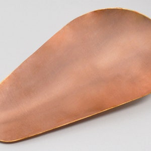 May include: A copper-colored, oval-shaped serving tray with a slightly raised edge. The tray has a brushed finish and a warm, metallic sheen.