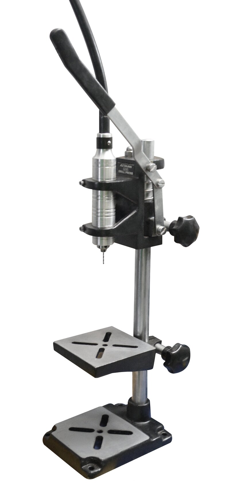 May include: A black drill press with a silver drill bit and a black handle. The drill press has a silver base and a black platform.